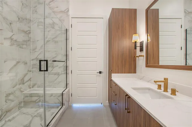 a bathroom with a granite countertop sink a vanity and a shower