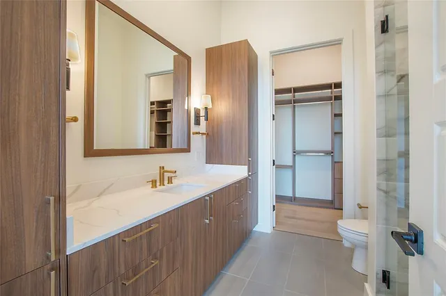 a bathroom with a double vanity sink mirror and toilet