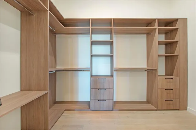 a view of walk in closet with empty racks