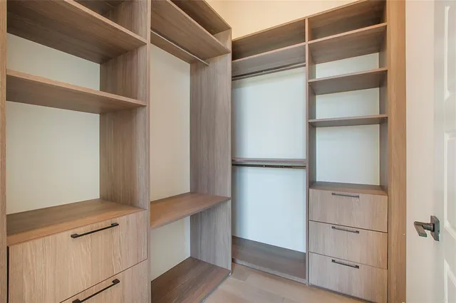a view of walk in closet with empty racks