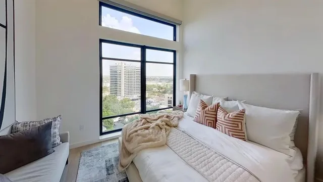 a bedroom with a bed and a large window