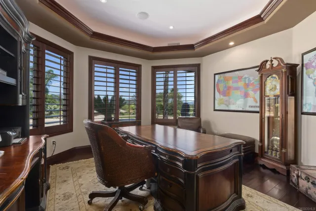 a view of a house with palm trees and a small yard