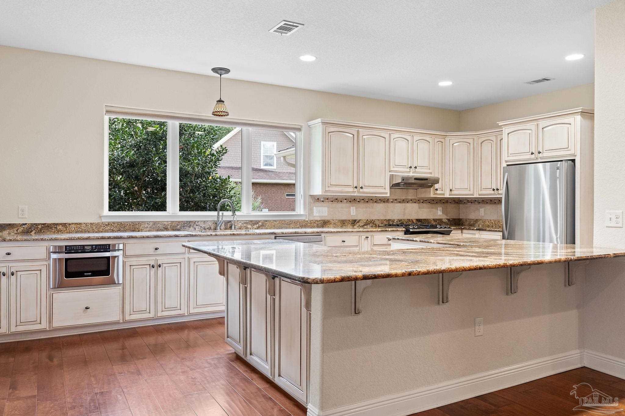 8664 Foxtail Loop Pensacola, FL 32526 - Photo 19 of 46 a kitchen with stainless steel appliances granite countertop a stove and white cabinets