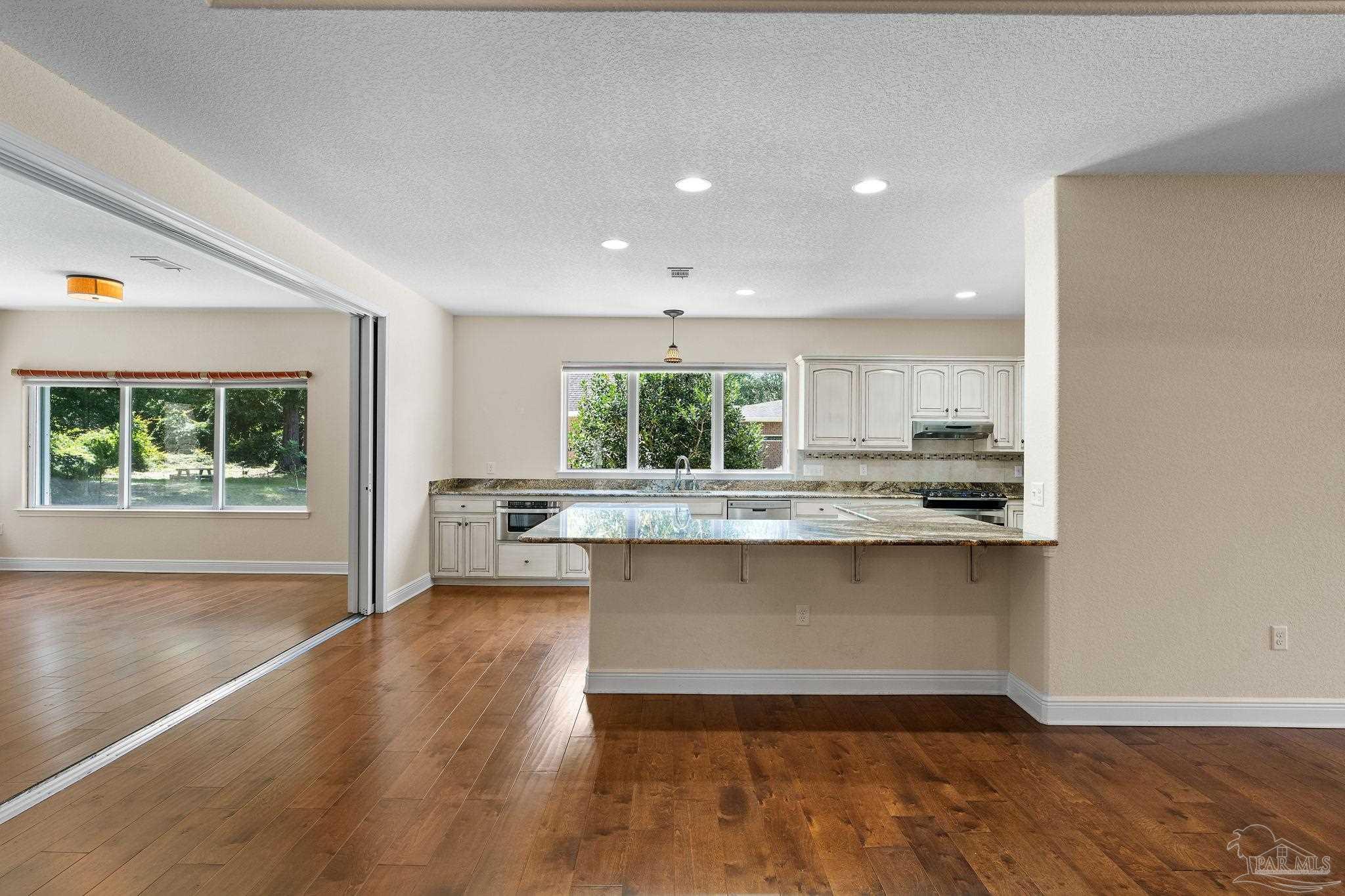8664 Foxtail Loop Pensacola, FL 32526 - Photo 20 of 46 a kitchen with stainless steel appliances granite countertop a stove a sink and a large window