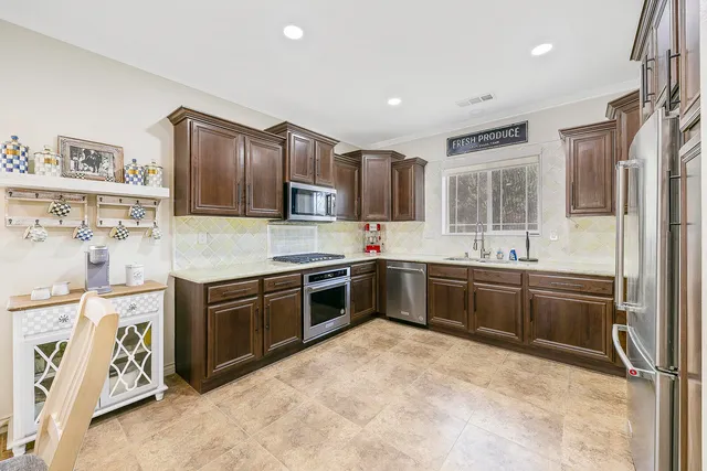 a kitchen with granite countertop a refrigerator and a sink