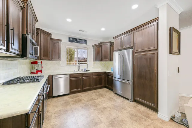 a kitchen with stainless steel appliances granite countertop a refrigerator and a stove top oven