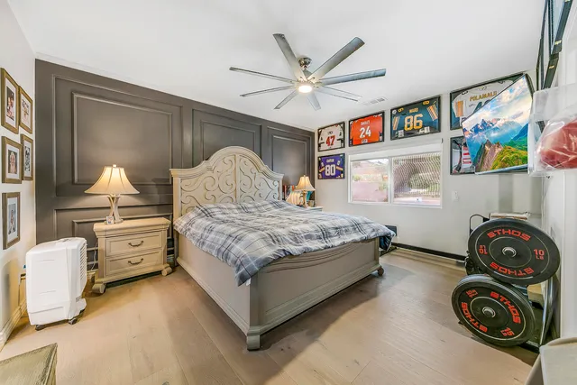 a bedroom with a bed and painting on the wall