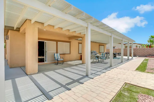 a view of a patio with a table chairs and wooden fence