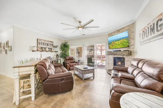 a living room with furniture a fireplace and a flat screen tv