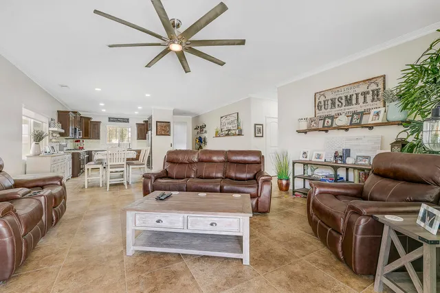 a living room with furniture a fireplace and a ceiling fan