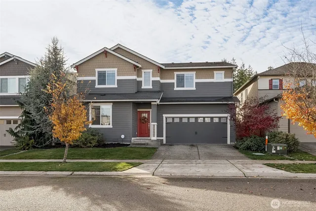 a front view of a house with a garden and garage