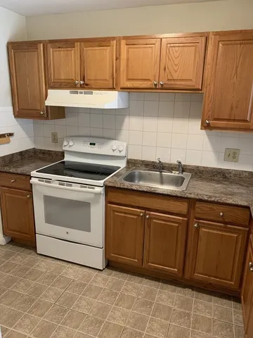 a kitchen with granite countertop a sink and cabinets