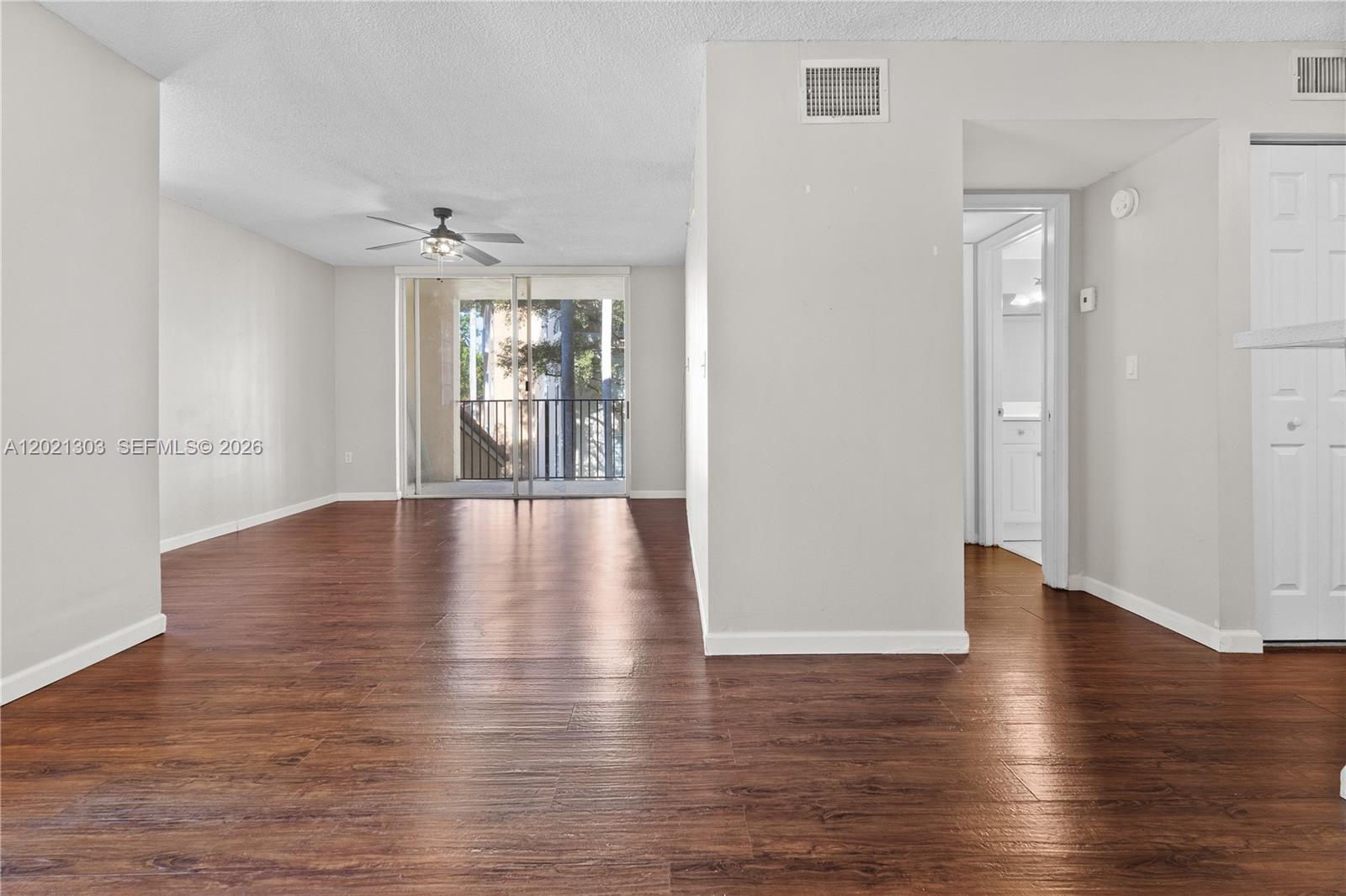 2123 Renaissance Boulevard, Unit 201 Miramar, FL 33025 - Photo 10 of 22 an empty room with wooden floor and windows