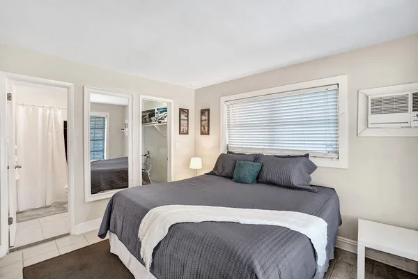 a bedroom with a large bed and a window