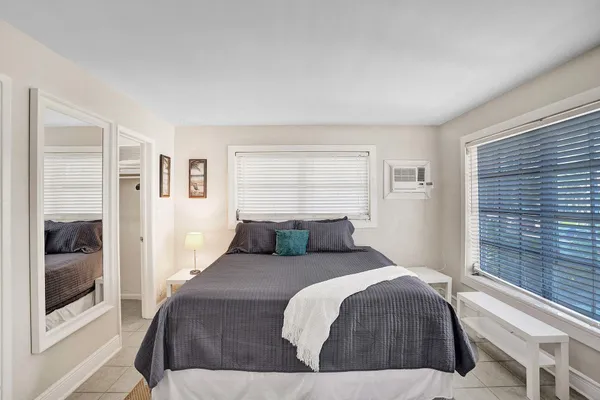 a bedroom with a bed and a large window