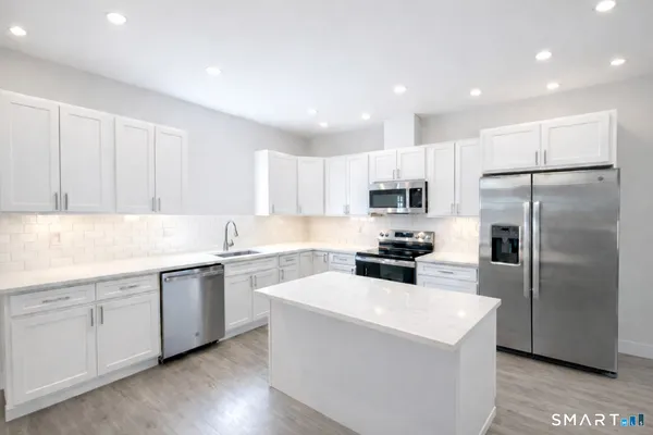 a kitchen with white cabinets and stainless steel appliances