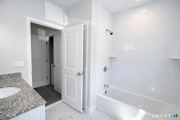a spacious bathroom with a granite countertop tub sink and mirror