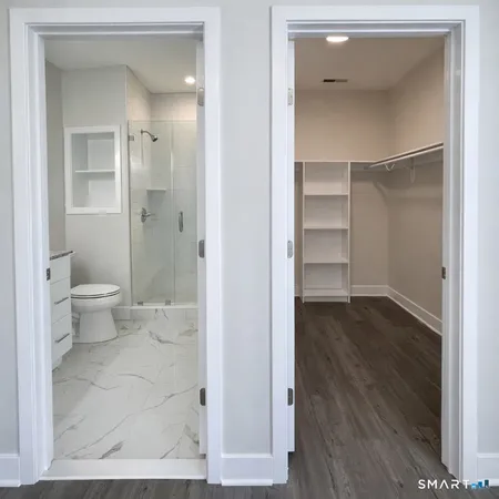 a bathroom view of a toilet and a mirror