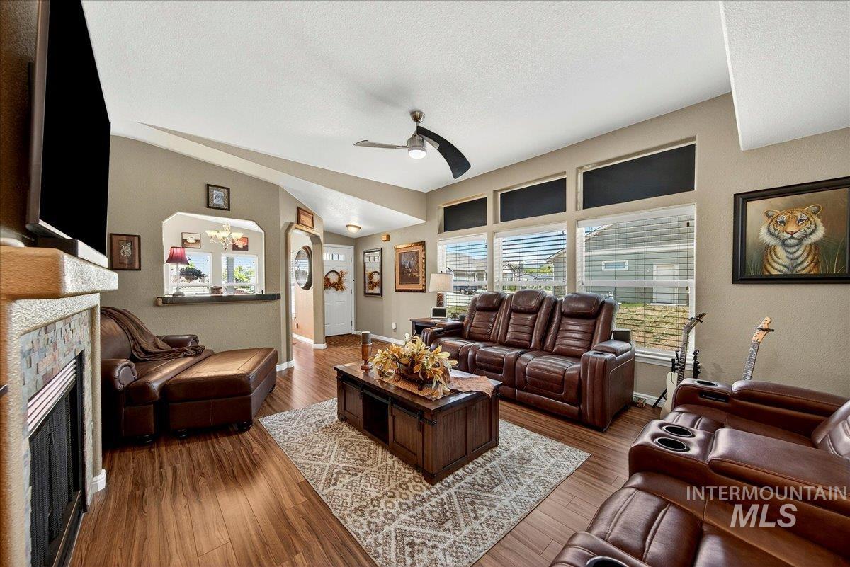 421 South Curtis Road, Unit 118 Boise, ID 83705 - Photo 12 of 49 Living room featuring a stone fireplace, a ceiling fan, hardwood / wood-style flooring, and arched walkways