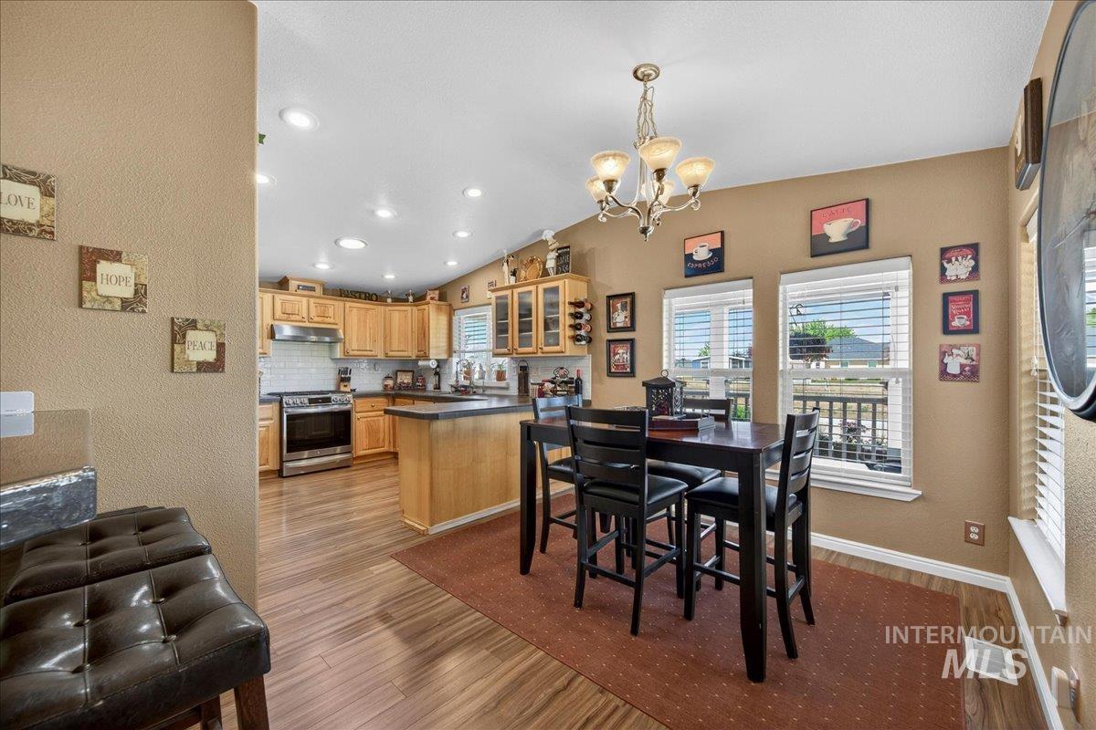 421 South Curtis Road, Unit 118 Boise, ID 83705 - Photo 14 of 49 Dining area featuring a textured wall, dark wood finished floors, a chandelier, and lofted ceiling
