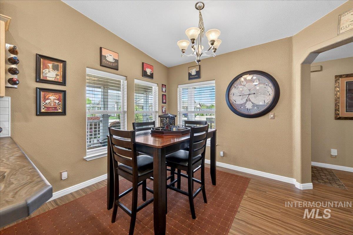 421 South Curtis Road, Unit 118 Boise, ID 83705 - Photo 16 of 49 Dining space featuring hanging lights, a textured wall, wood finished floors, and arched walkways