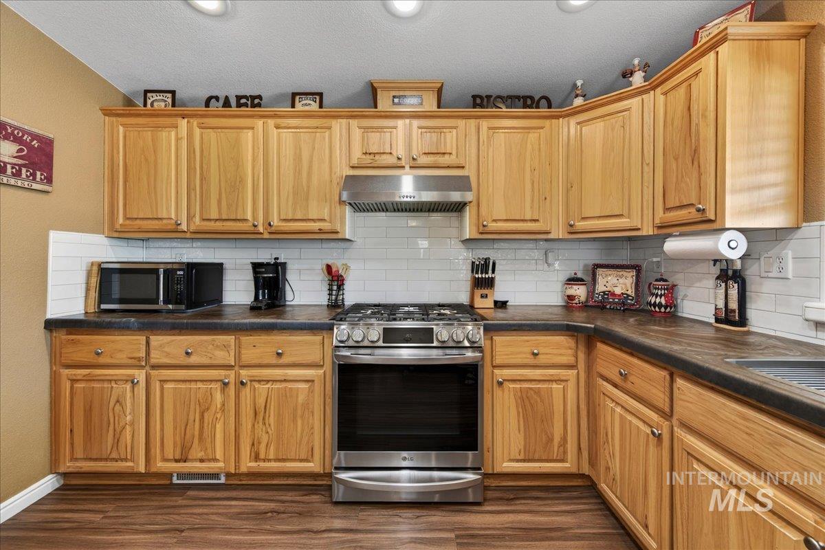 421 South Curtis Road, Unit 118 Boise, ID 83705 - Photo 20 of 49 Kitchen with stainless steel appliances, dark countertops, ventilation hood, and dark wood-style flooring