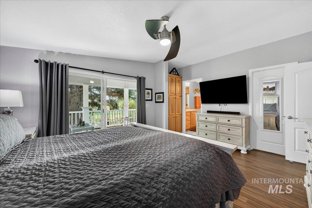 421 South Curtis Road, Unit 118 Boise, ID 83705 - Photo 30 of 49 Bedroom featuring ceiling fan, access to outside, ensuite bathroom, dark wood-type flooring, and a textured ceiling