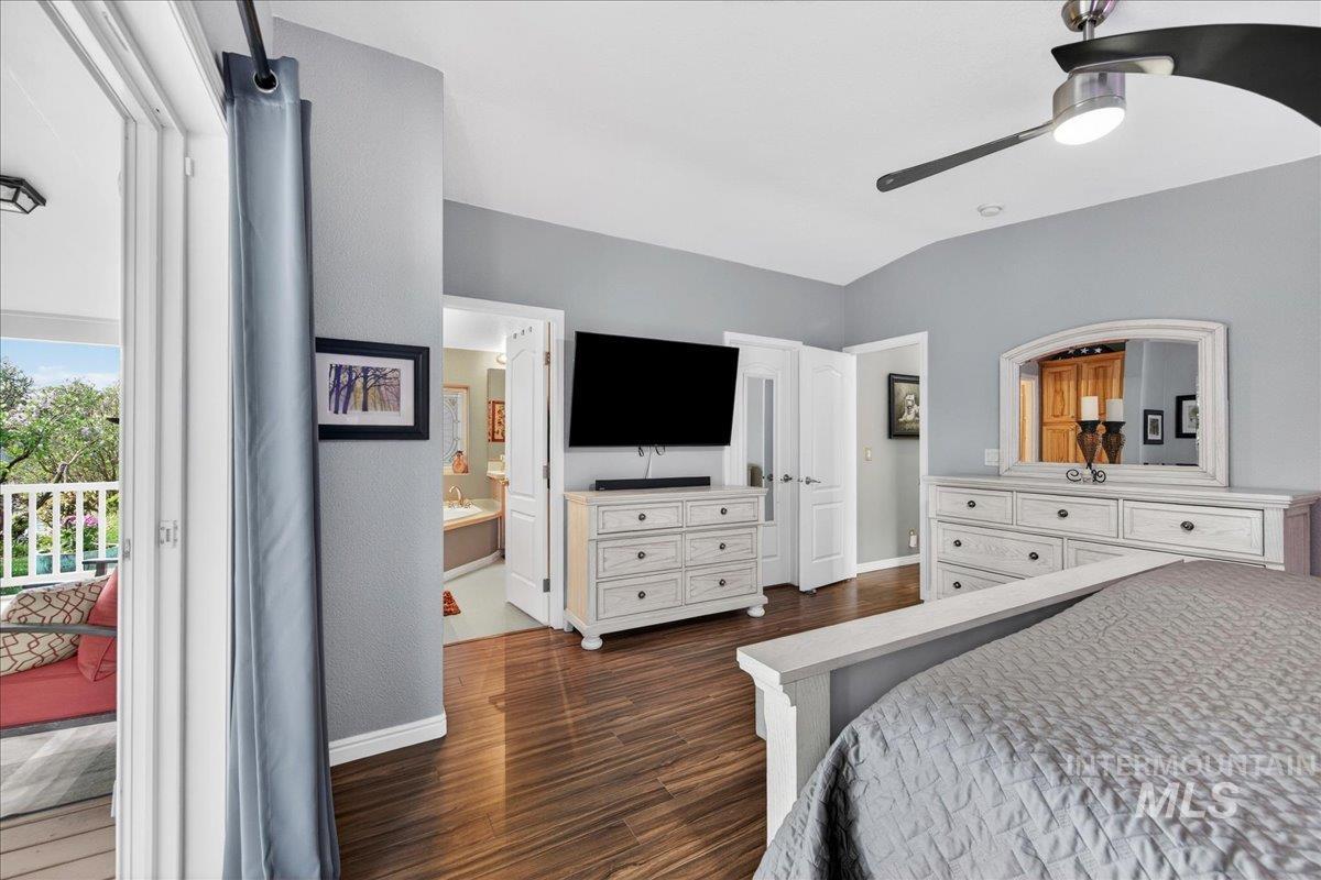 421 South Curtis Road, Unit 118 Boise, ID 83705 - Photo 31 of 49 Bedroom featuring dark wood-type flooring, a ceiling fan, vaulted ceiling, and access to exterior