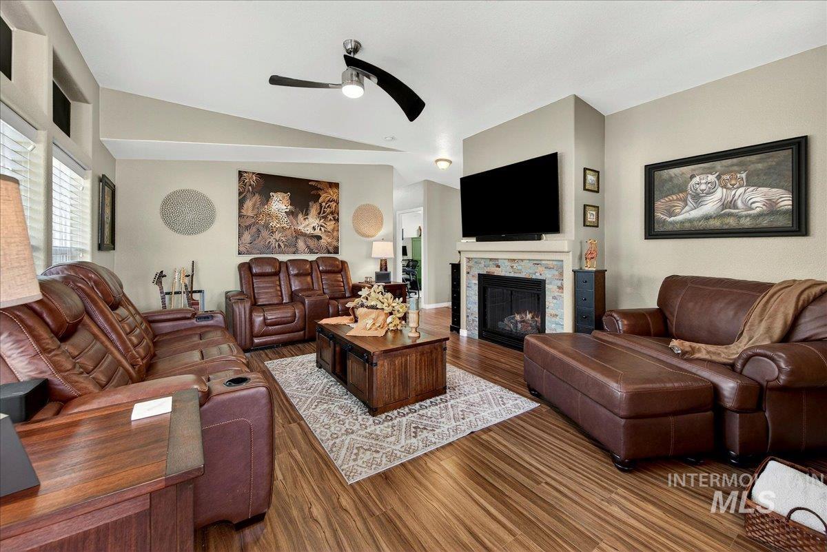 421 South Curtis Road, Unit 118 Boise, ID 83705 - Photo 9 of 49 Living room featuring a tile fireplace, dark wood-style floors, ceiling fan, and vaulted ceiling