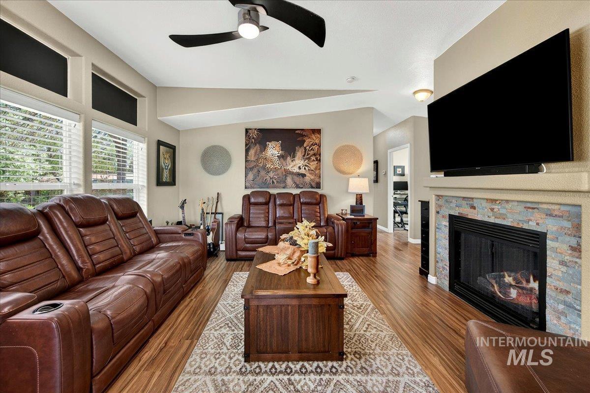 421 South Curtis Road, Unit 118 Boise, ID 83705 - Photo 10 of 49 Living room featuring ceiling fan, a glass covered fireplace, wood finished floors, and vaulted ceiling