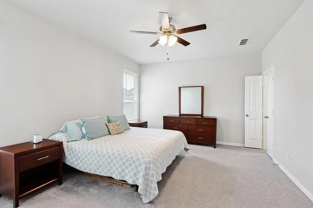 a bedroom with a bed and a ceiling fan