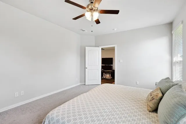 a bedroom with a bed and a ceiling fan
