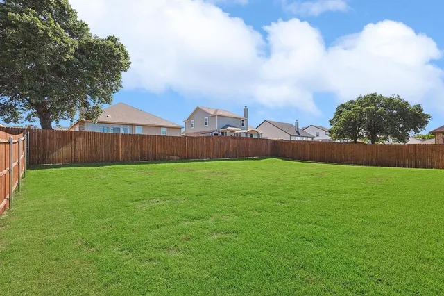 a view of yard with swimming pool and wooden fence