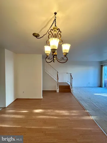 a view of a room with wooden floor and ceiling fan
