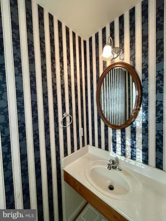 a bathroom with a sink a mirror a bathtub and a window