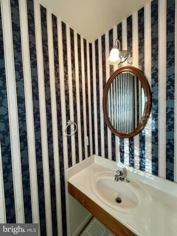 a bathroom with a sink a mirror a bathtub and a window