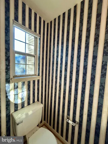 a white toilet sitting next to a window