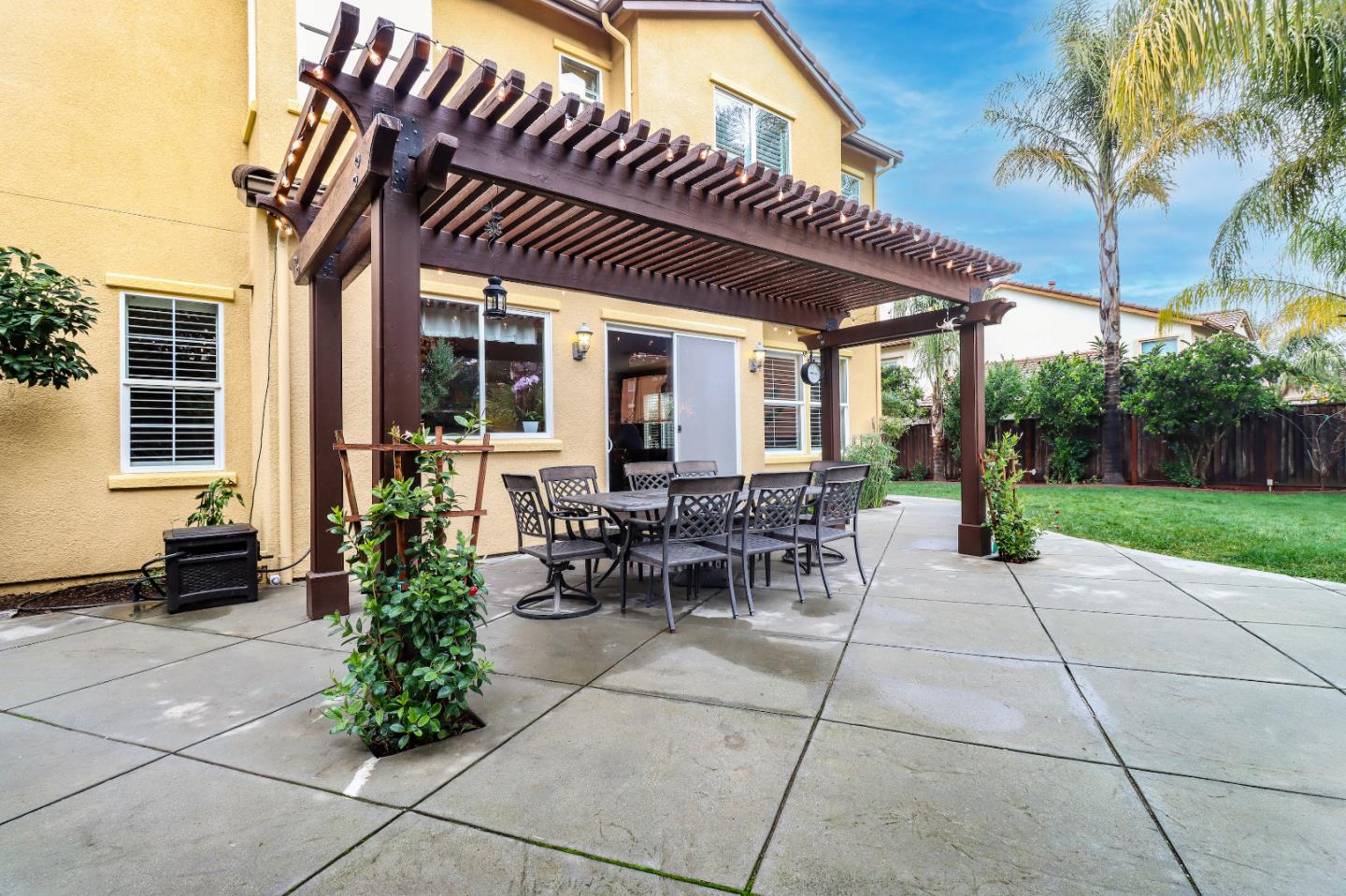 1960 County Down Way Gilroy, CA 95020 - Photo 43 of 62 a view of a patio with table and chairs potted plants and palm trees