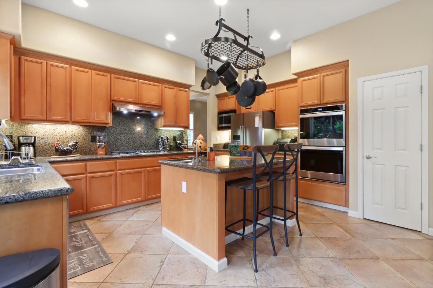 1960 County Down Way Gilroy, CA 95020 - Photo 8 of 62 a kitchen with stainless steel appliances granite countertop a table chairs sink and cabinets
