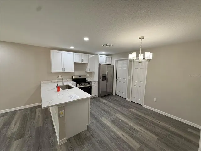 a view of a kitchen with an empty space and wooden floor