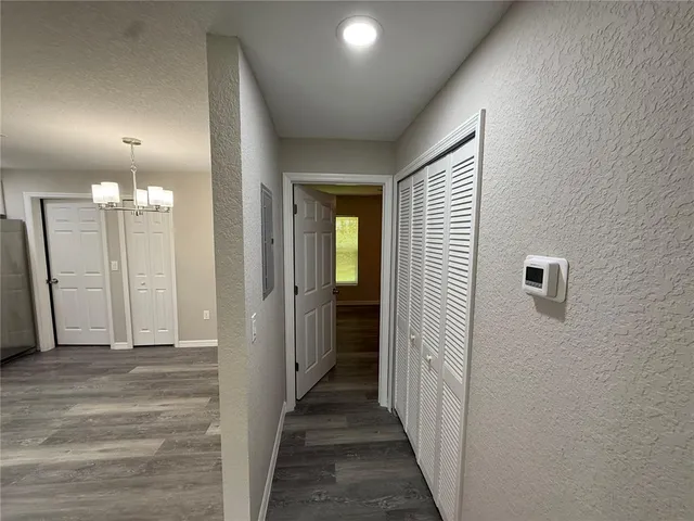 a view of a hallway with wooden floor and staircase