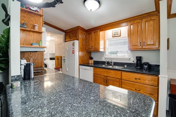 a kitchen with stainless steel appliances granite countertop a refrigerator a sink and a stove top oven