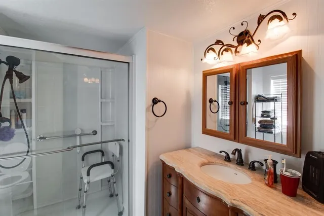 a bathroom with a granite countertop sink mirror and vanity