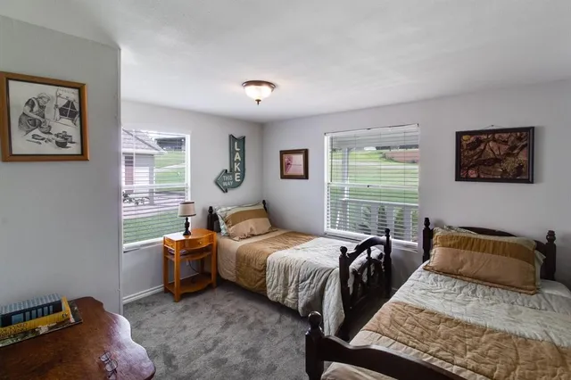 a bed room with a bed and two windows