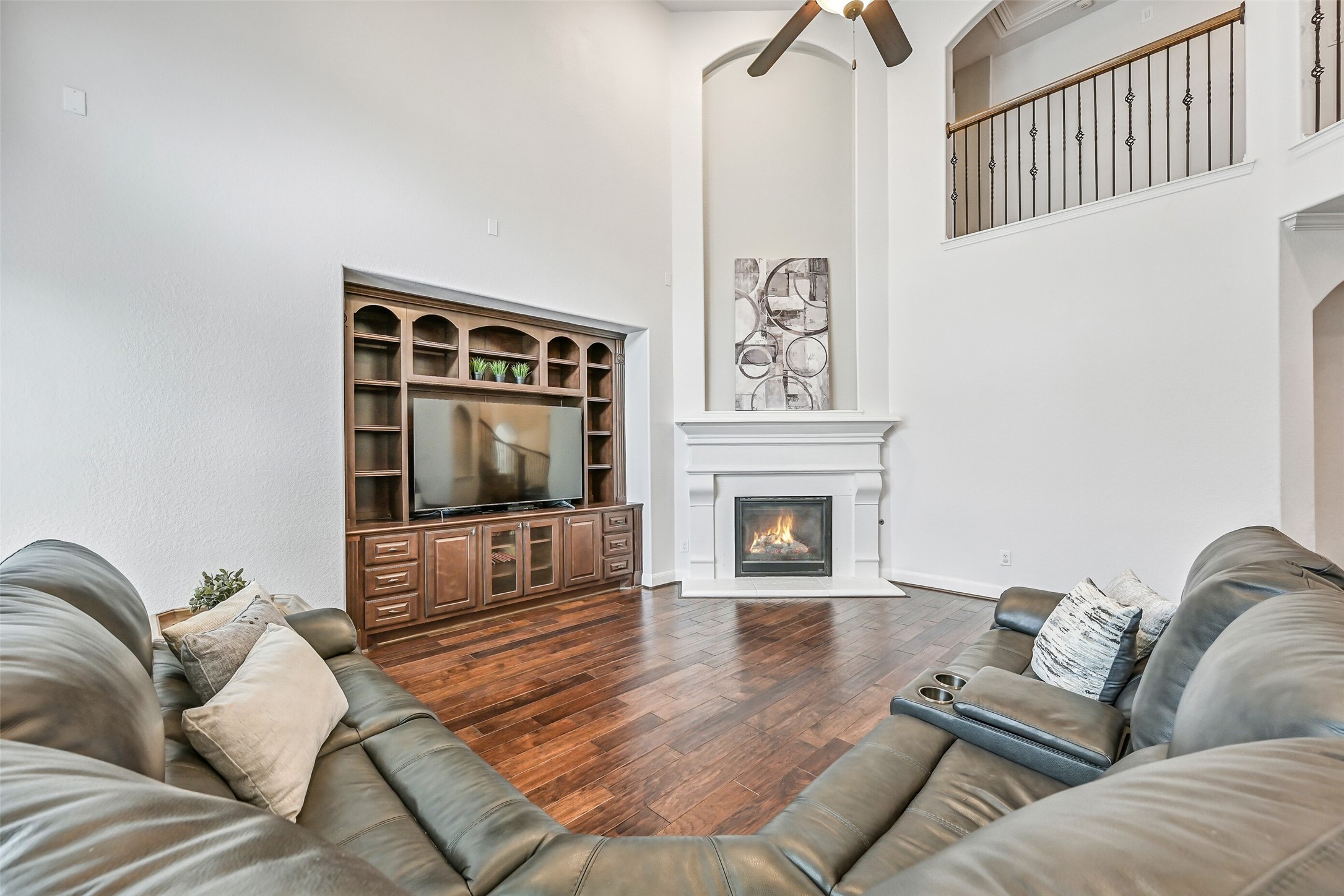 1008 Point Isabel Lane Friendswood, TX 77546 - Photo 22 of 50 A detailed cast stone fireplace serves as the focal point, complemented by a built-in stained wood entertainment center that provides storage and space for media equipment.