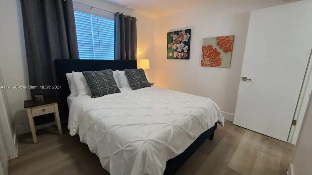 649 Southwest 9th Street, Unit 108 Miami, FL 33130 - Photo 2 of 7 a large bed sitting in a bedroom next to a window