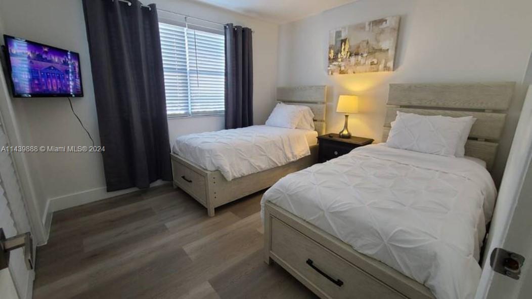 649 Southwest 9th Street, Unit 108 Miami, FL 33130 - Photo 3 of 7 a bedroom with two beds and painting on the wall