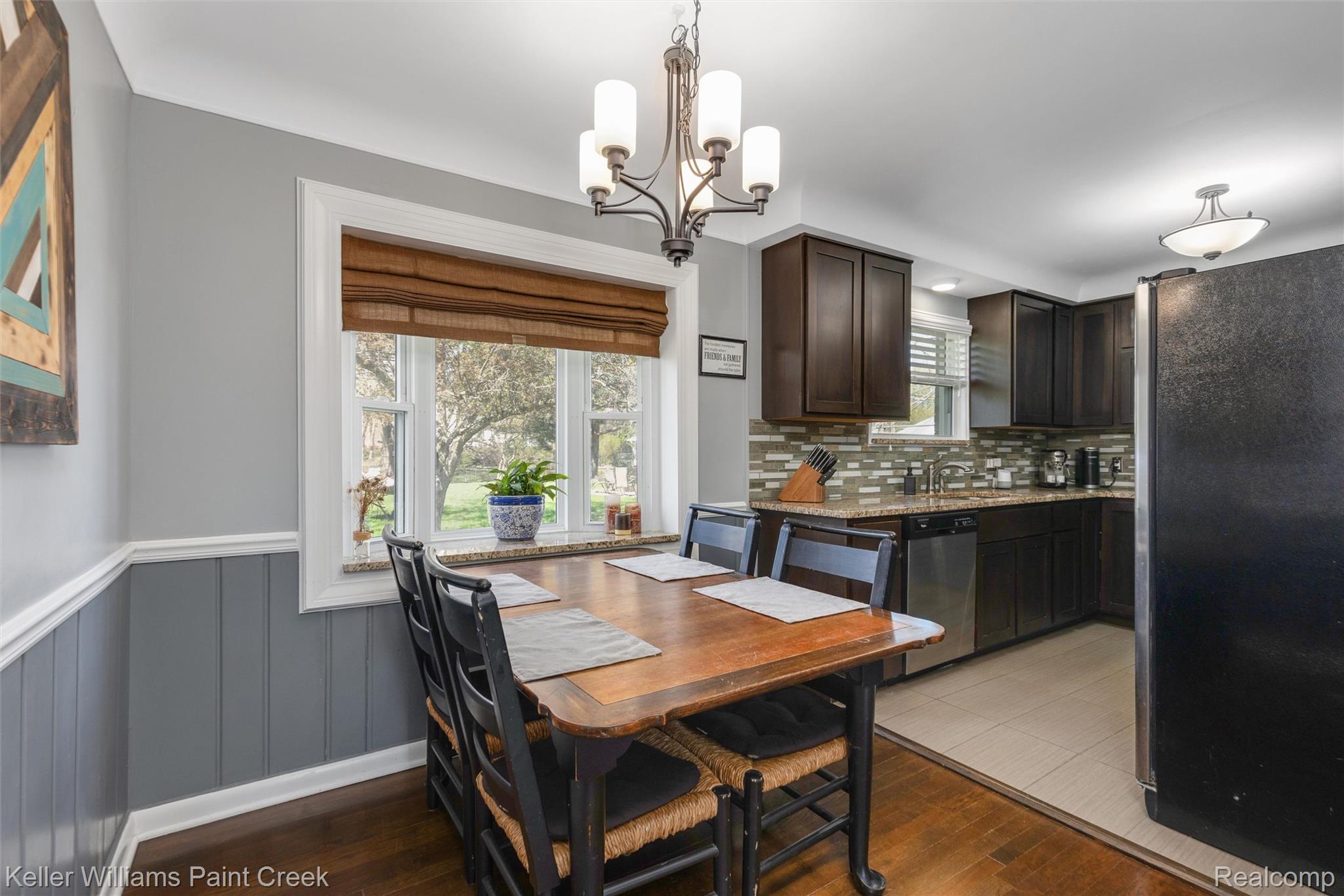 310 Elmhill Road Rochester, MI 48306 - Photo 11 of 37 Dining area featuring hanging lights, a wainscoted wall, and light wood-type flooring
