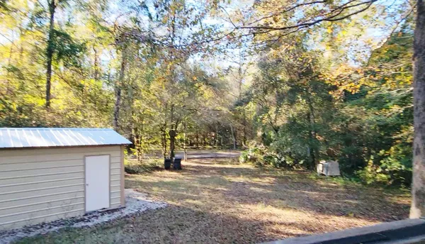 a view of a backyard with table and chairs under an umbrella
