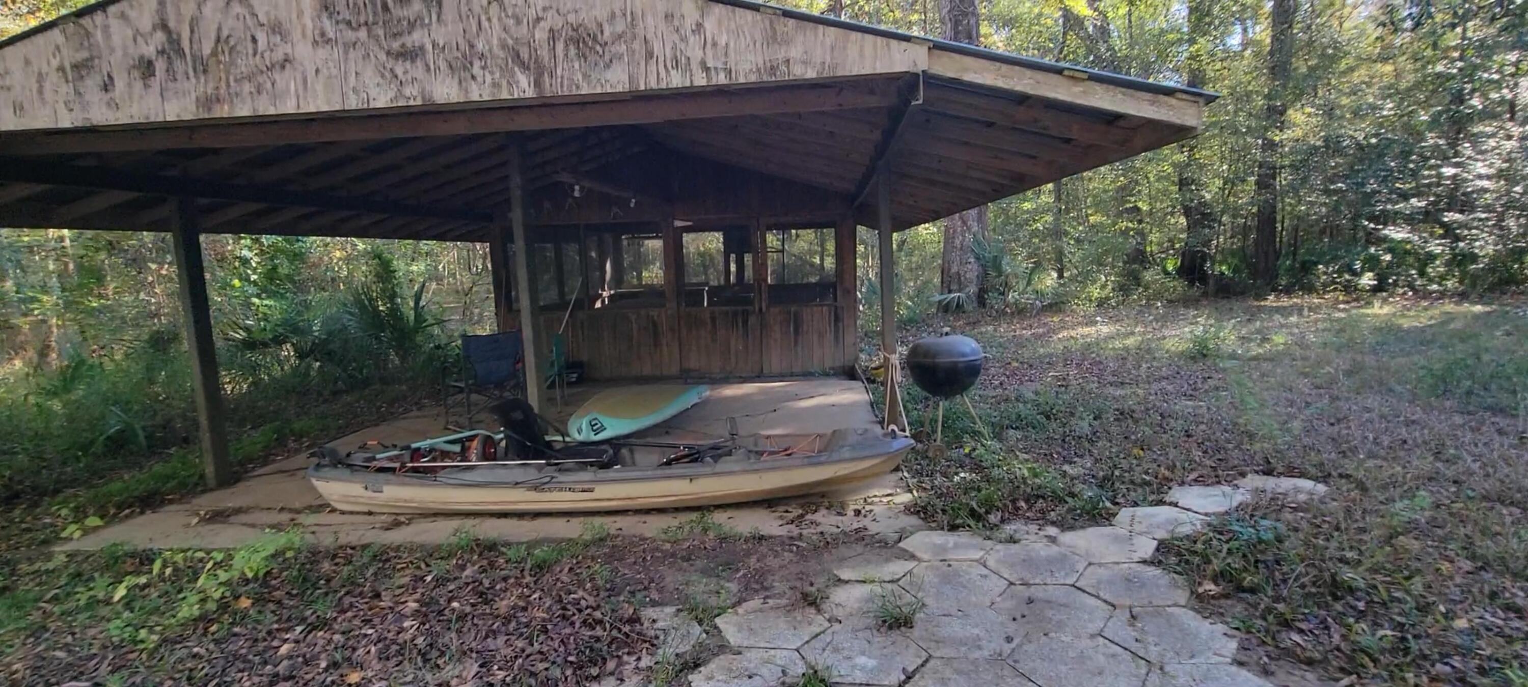 1907 River Road Ponce de Leon, FL 32455 - Photo 22 of 63 a view of a backyard with table and chairs under an umbrella